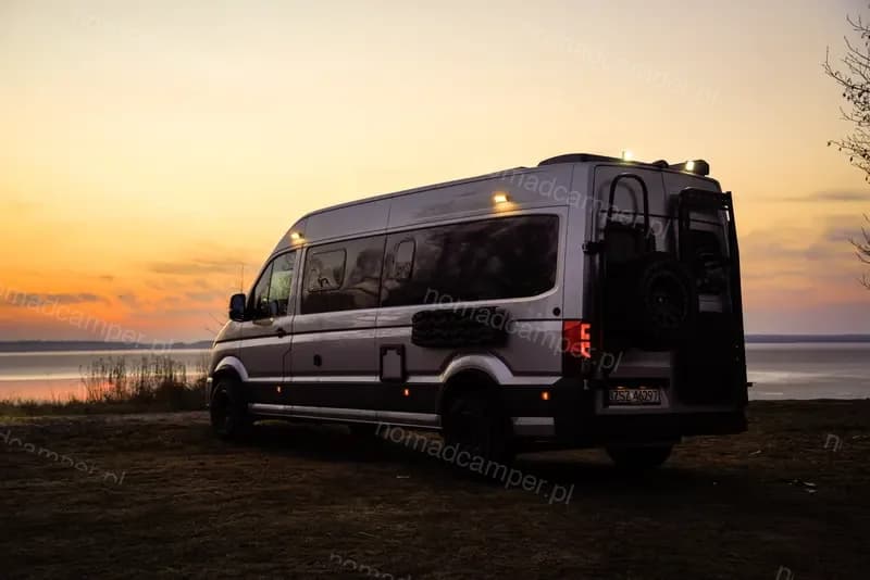 Kamper nad jeziorem o zachodzie słońca