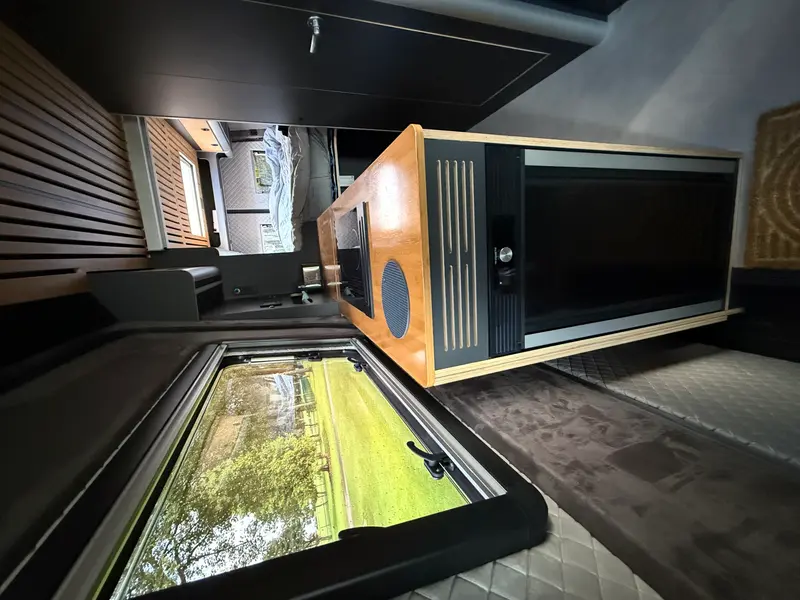 Wnętrze sypialny z oknem dachowym i drewnianą zabudową